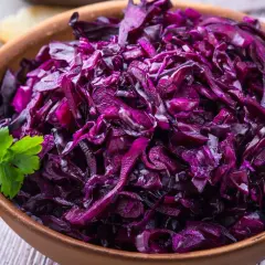 Pyszna surówka z czerwonej kapusty, jak w restauracji, podana w glinianej misie z natką pietruszki i kromką chleba.