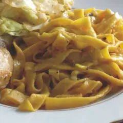 Pyszne tagliatelle z kurczakiem i warzywami na talerzu.