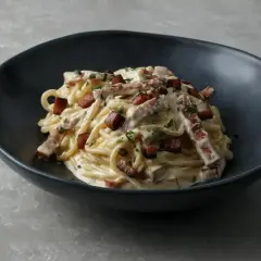 Pyszne spaghetti carbonara z chrupiącym boczkiem i kremowym sosem. Idealne carbonara skladniki.