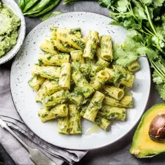 Makaron z pesto ze słoika, podany na talerzu, z awokado i świeżymi ziołami.