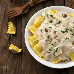Pyszne ravioli w kremowym sosie śmietanowym z grzybami i natką pietruszki. Idealny sos śmietanowy do makaronu.