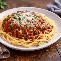 Pyszne spaghetti z bogatym sosem mięsnym na bazie passaty, posypane parmezanem i natką pietruszki. Idealne na obiad.