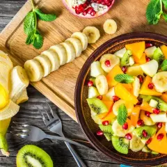 Kolorowa sałatka owocowa z kiwi, bananem, mango i granatem. Idealna na deser, zastanawiasz się, jaki sos do sałatki owocowej będzie najlepszy?