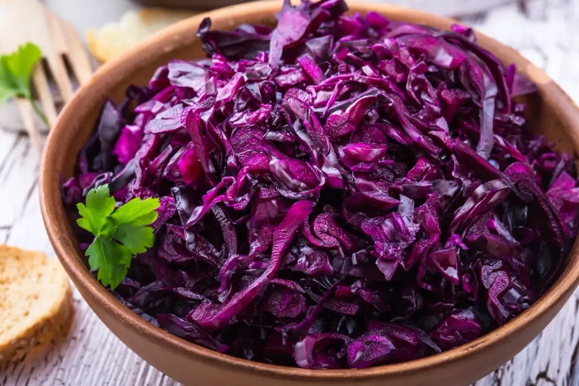 Pyszna surówka z czerwonej kapusty, jak w restauracji, podana w glinianej misie z natką pietruszki i kromką chleba.