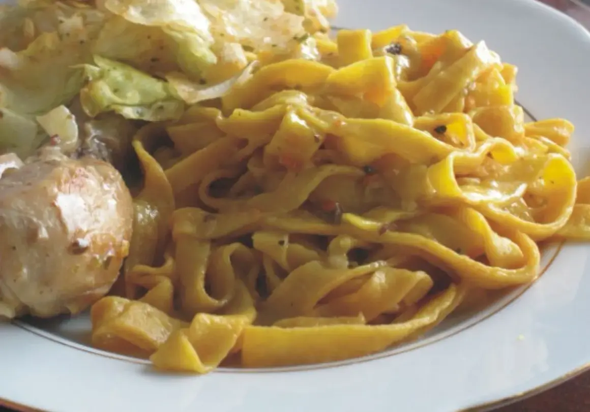 Pyszne tagliatelle z kurczakiem i warzywami na talerzu.