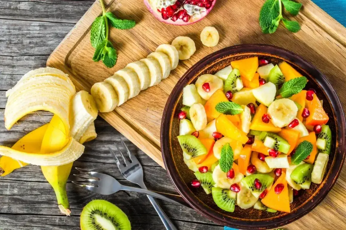 Kolorowa sałatka owocowa z kiwi, bananem, mango i granatem. Idealna na deser, zastanawiasz się, jaki sos do sałatki owocowej będzie najlepszy?