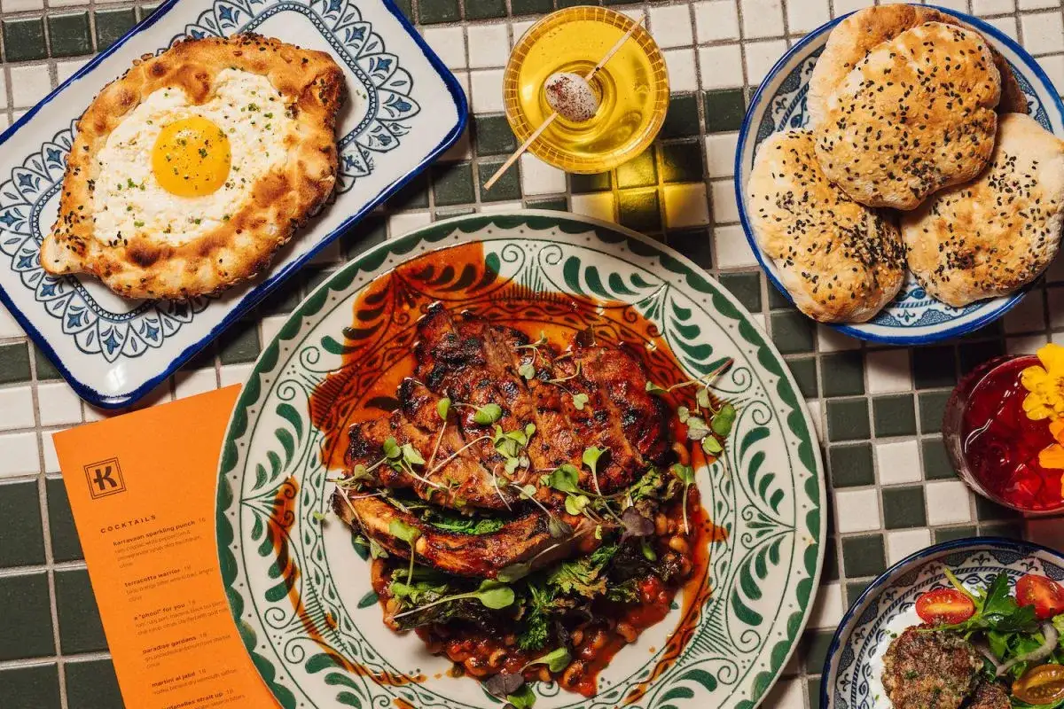 Pyszne dania kuchni fusion: chleb z jajkiem, grillowane mięso, pieczywo z sezamem i sałatka.