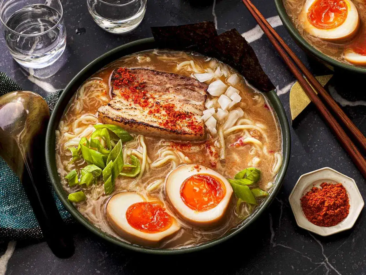 Apetyczny ramen z plastrem boczku, jajkiem na pół i szczypiorkiem. Idealny przepis, jak zrobić ramen, by zachwycić smakiem.